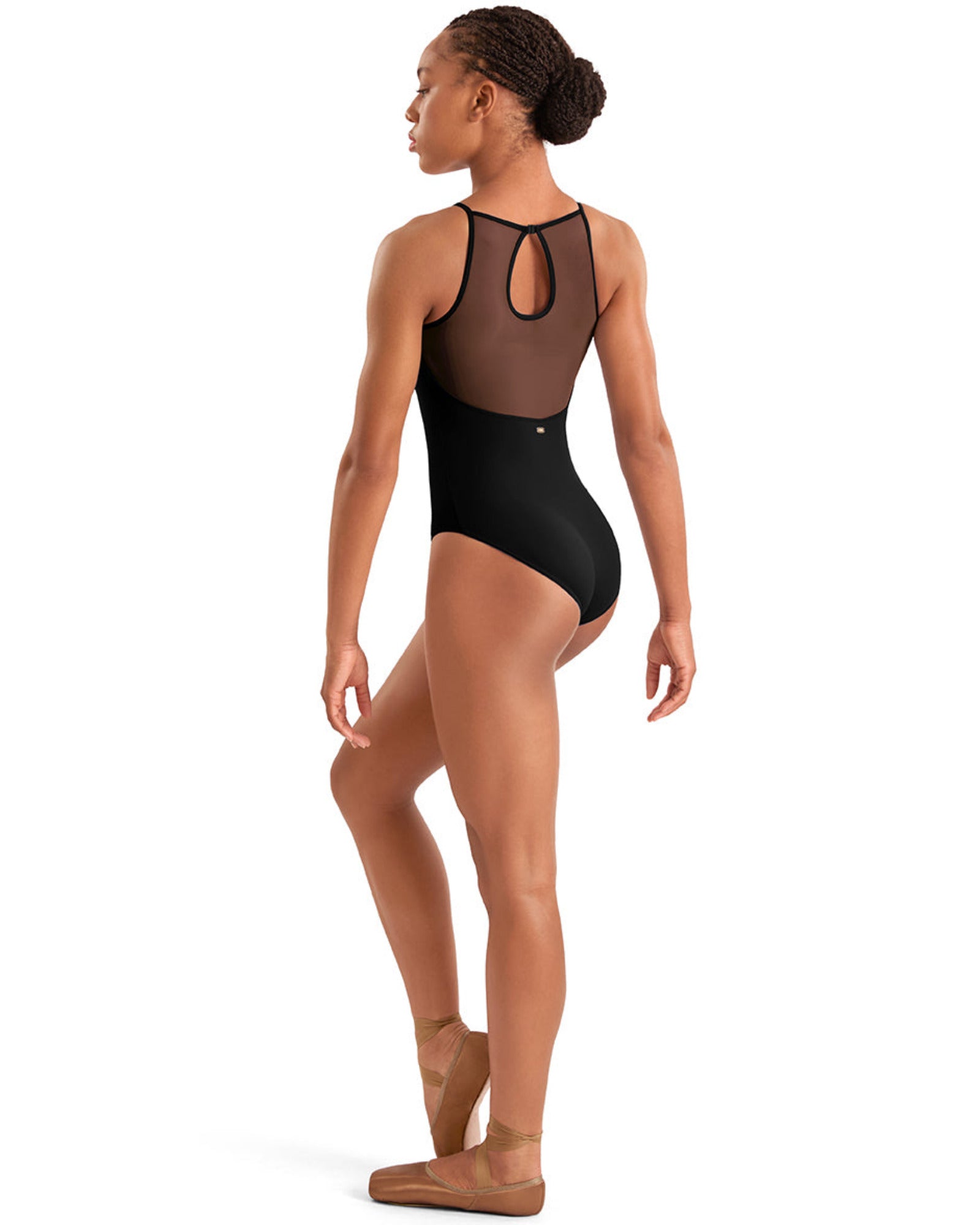 Dancer wearing a black leotard with mesh panels on a white background