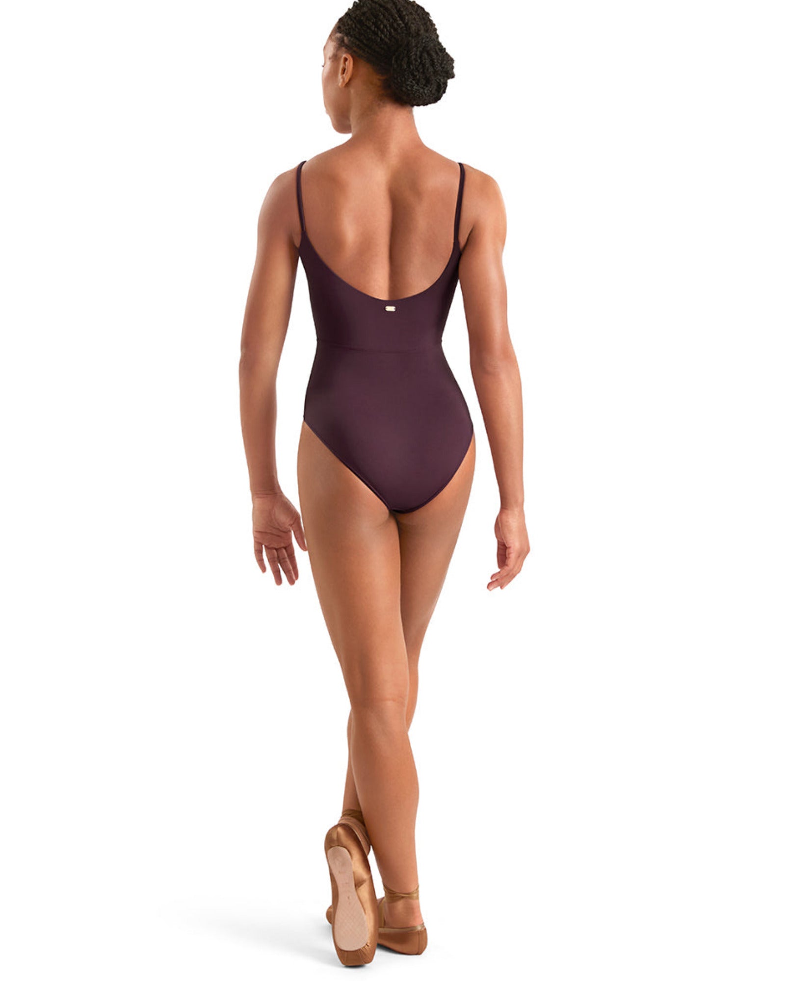 Woman wearing a dark plum leotard on a white background