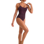 Model wearing a dark plum leotard and brown ballet shoes on a white background
