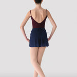Ballerina in a maroon leotard and navy skirt on a white background