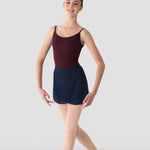 Ballerina in a maroon leotard with a navy skirt posing against a plain background