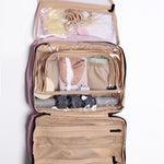 Open beige hanging travel organizer with toiletries on a white background