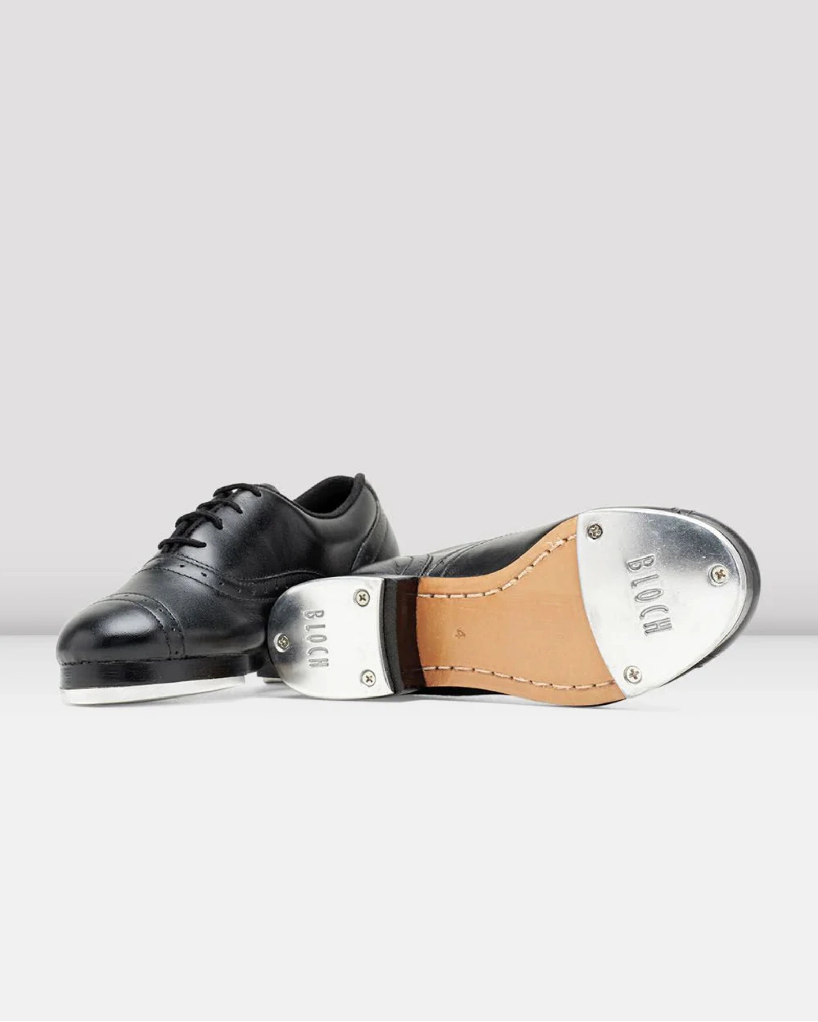 Black tap dance shoe with a metallic tap on a white background