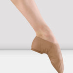 Jazz shoe worn by a dancer on a plain background
