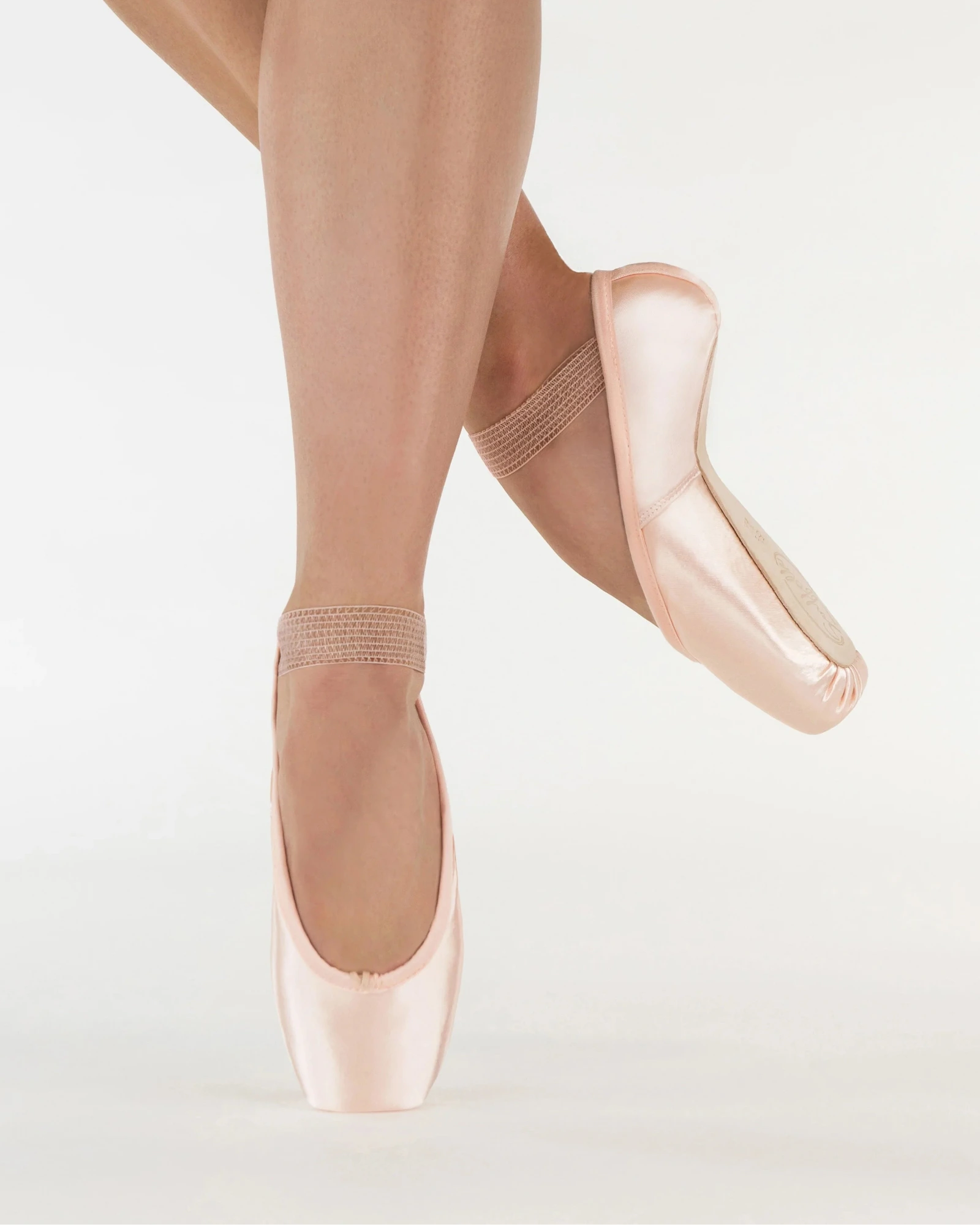 Ballet shoes worn with tights on a light background