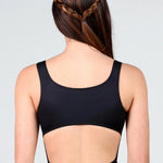 Person wearing a black leotard with cut-out design on a plain background