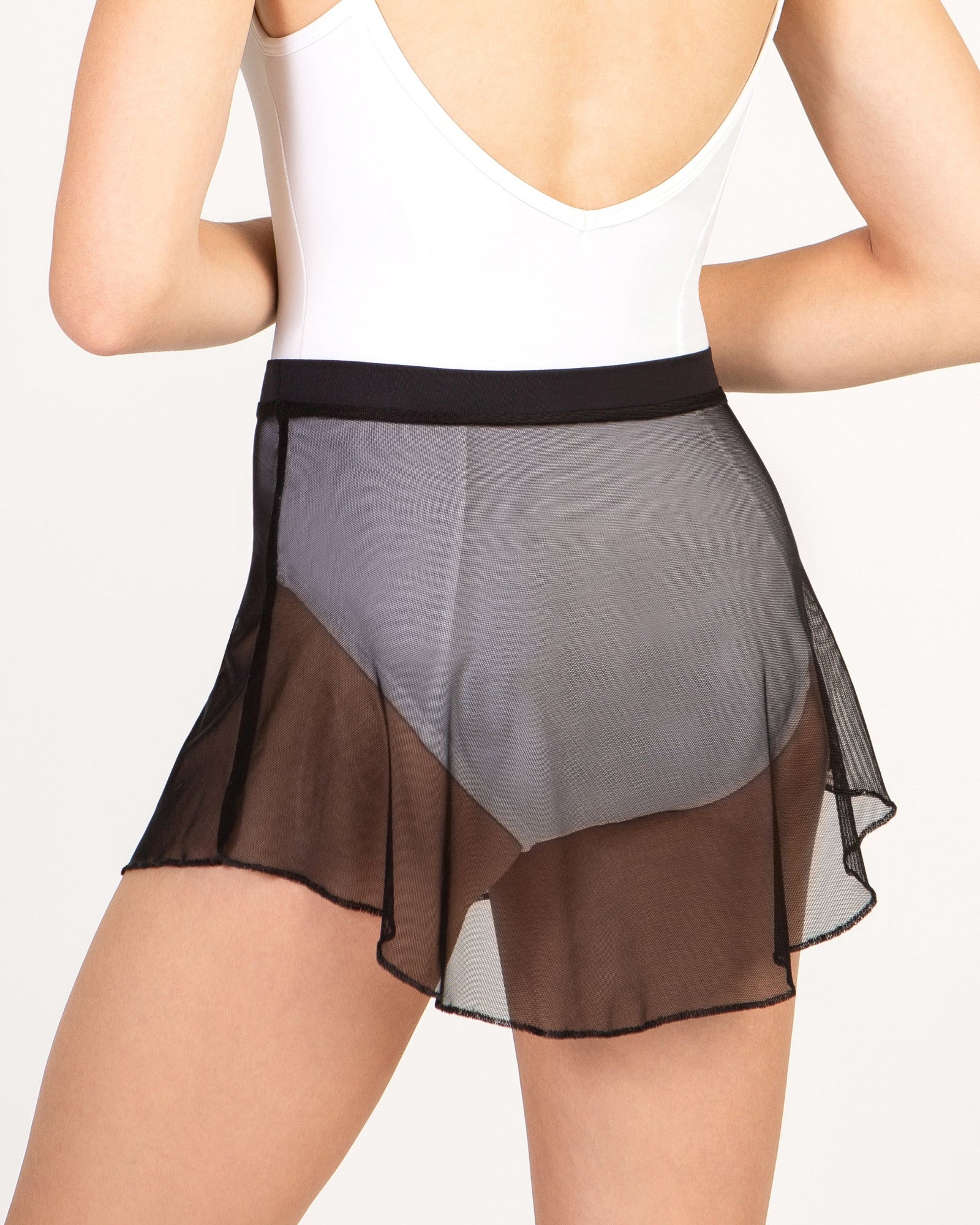 Person wearing a black mesh skirt on a plain background