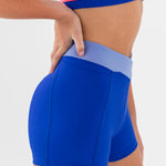 Blue dance shorts with a pink waistband on a white background