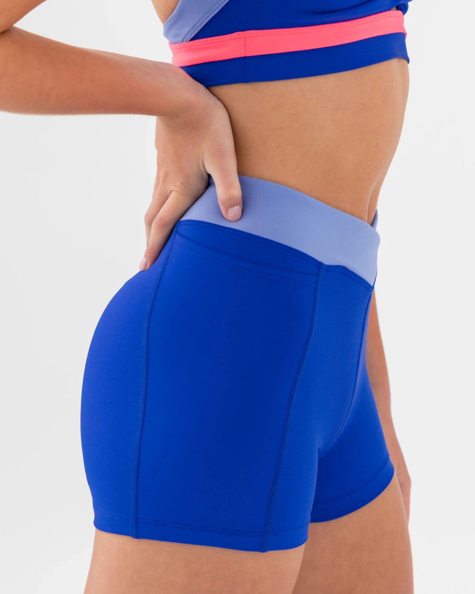 Blue dance shorts with a pink waistband on a white background