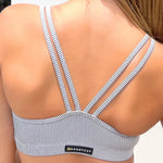 Woman wearing a striped dance top with 'Honeycut' branding.