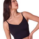 Woman wearing a black tank top against a white background