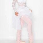 A model wearing a white long-sleeve lace top, a white tulle tutu skirt, light pink leggings, and ballet slippers, posing against a plain white studio background.