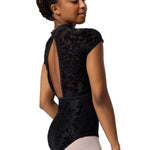 Person wearing a black floral-patterned leotard on a white background
