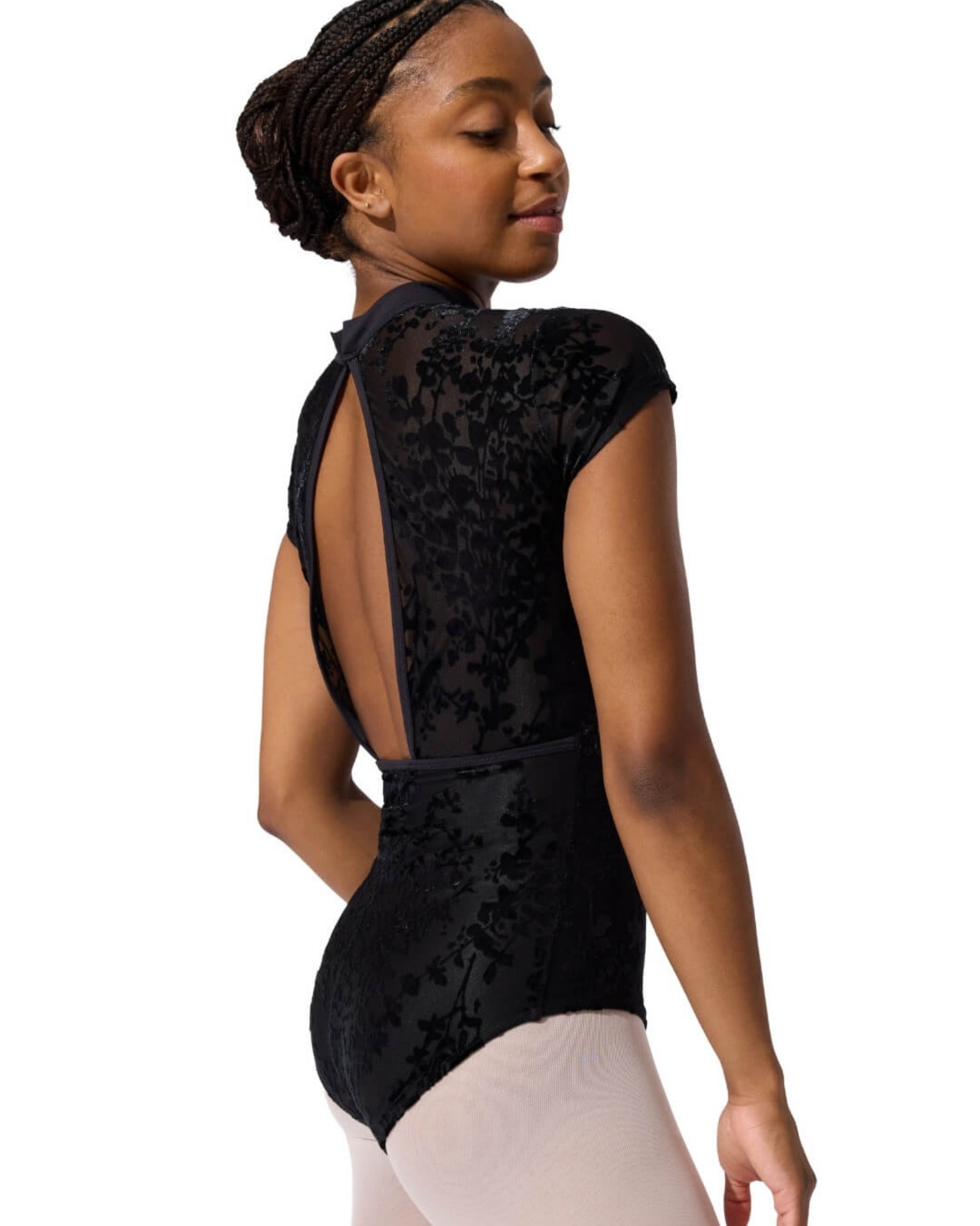 Person wearing a black floral-patterned leotard on a white background