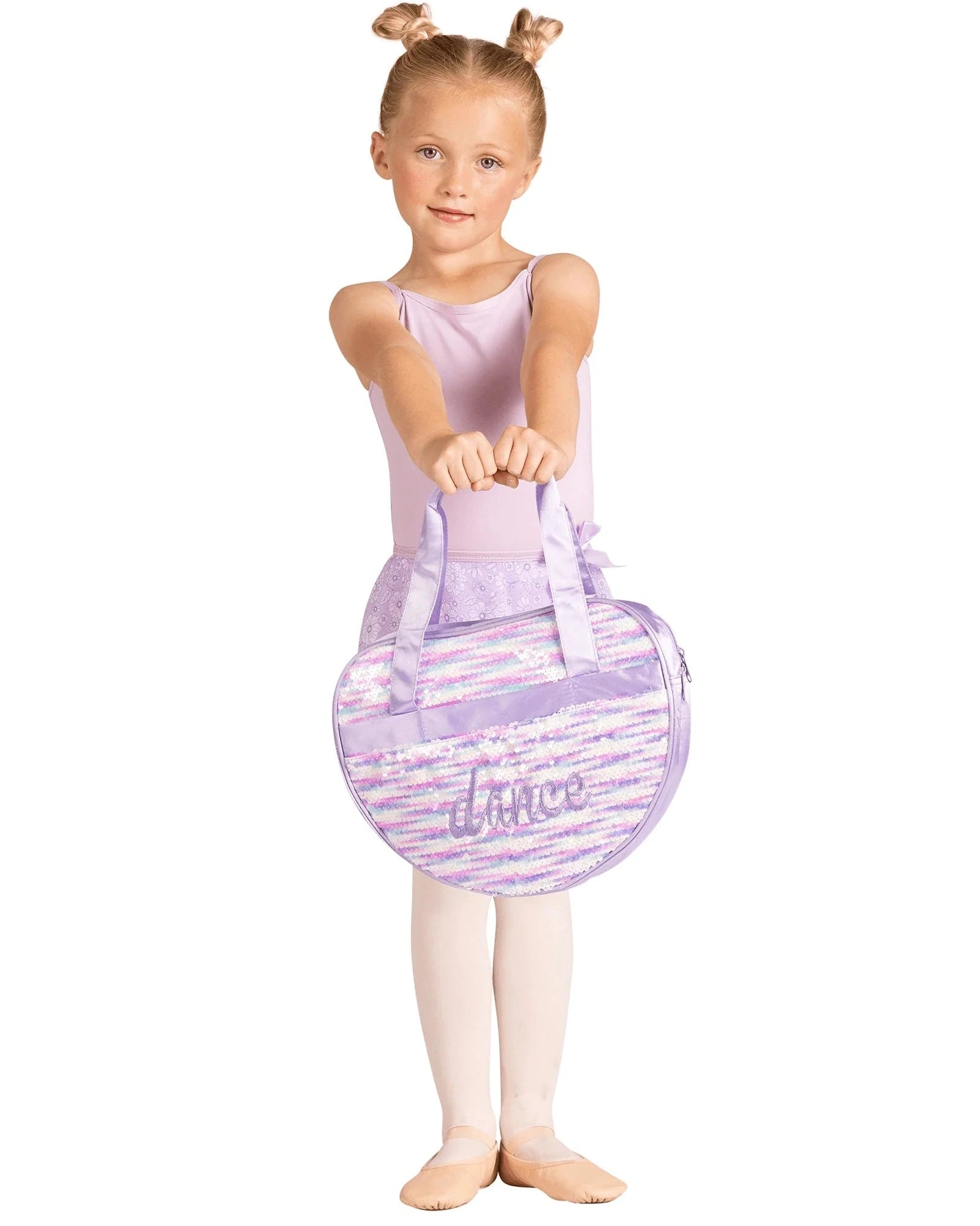 Young girl in ballet attire holding a purple ballet bag with 'dance' on a white background