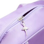 Close-up of a lavender purple nylon bag featuring a silver metal zipper with a dangling ballerina charm.