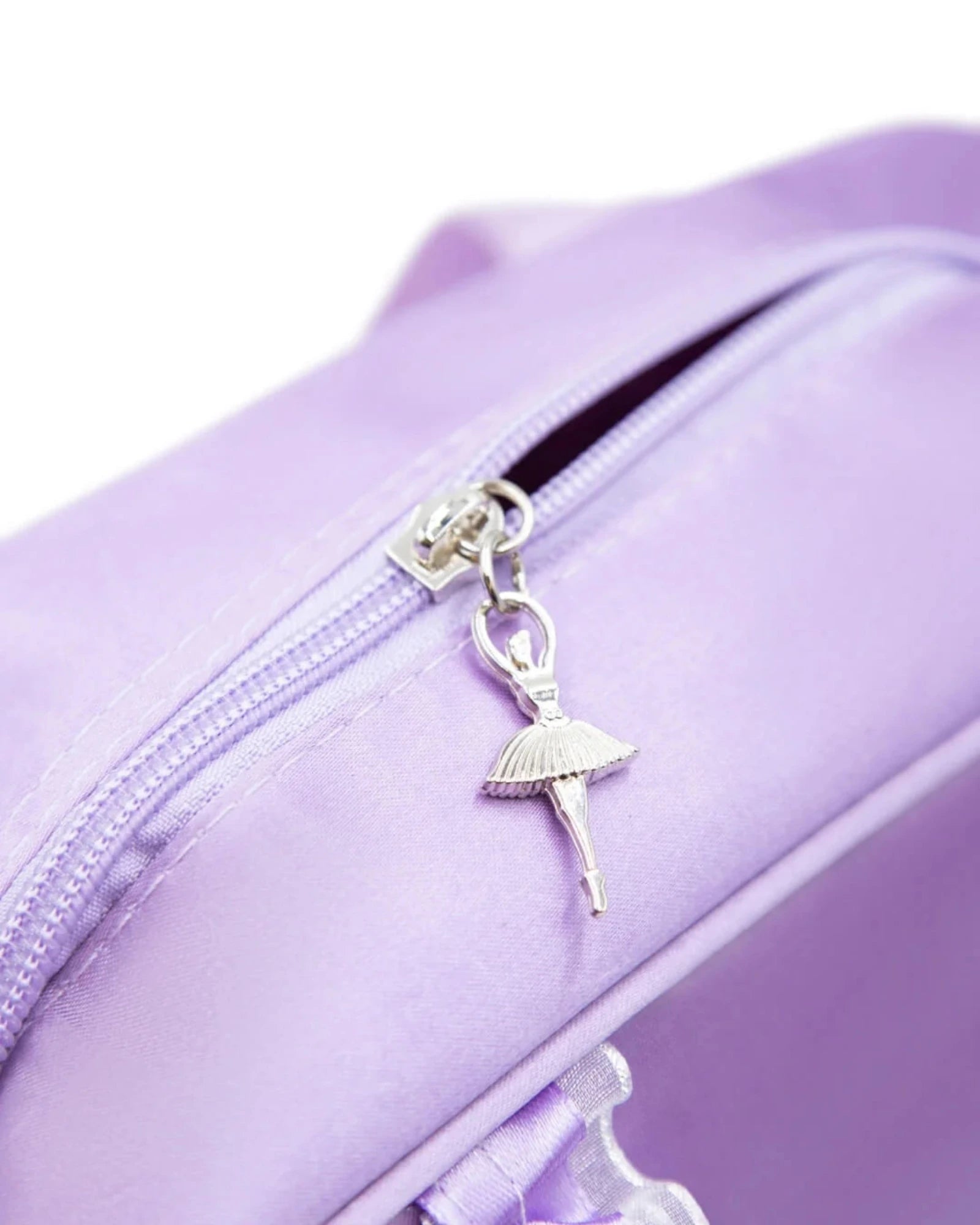 Close-up of a lavender purple nylon bag featuring a silver metal zipper with a dangling ballerina charm.