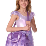 Young girl in a purple outfit holding a matching purple bag on a white background
