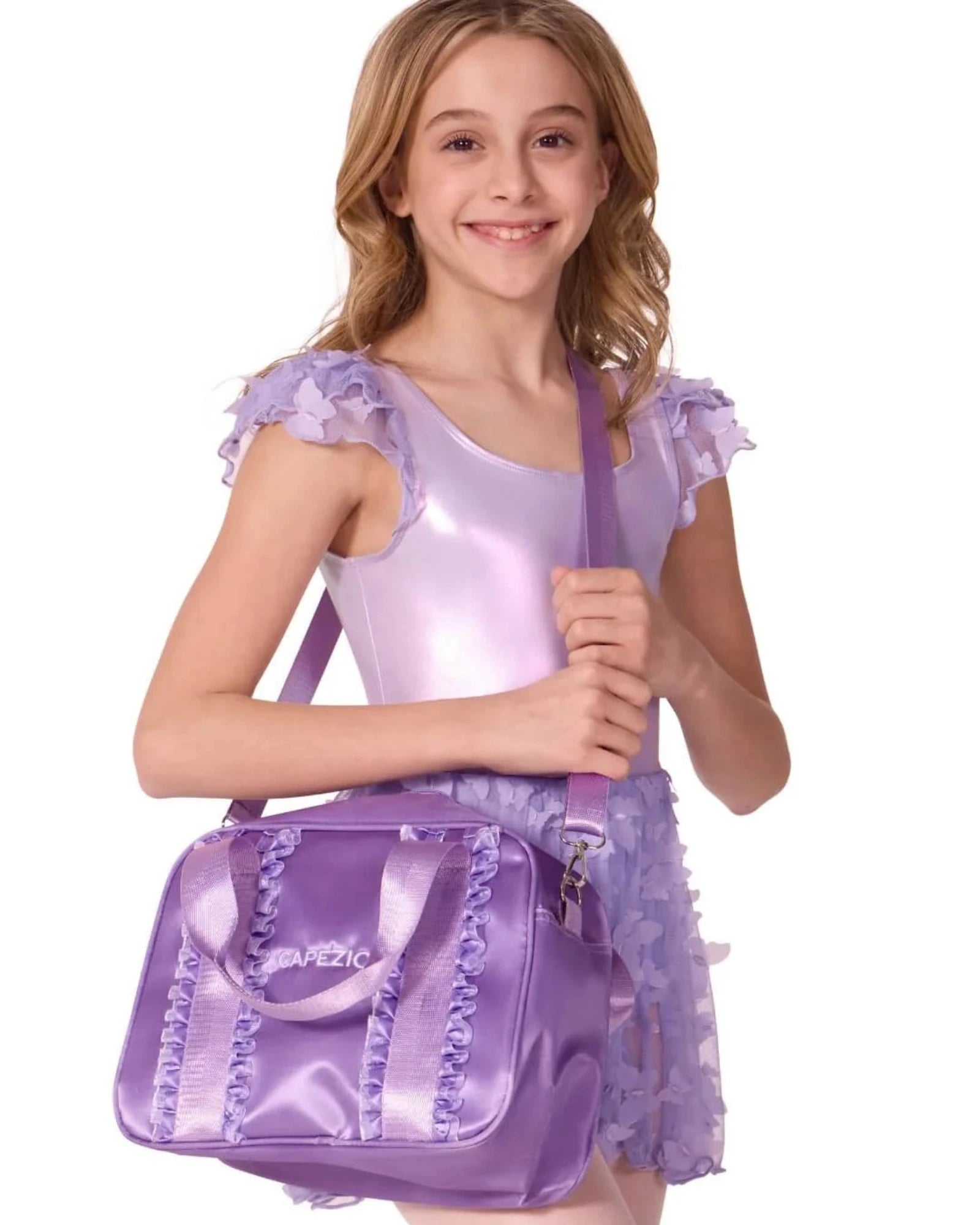 Young girl in a purple outfit holding a matching purple bag on a white background