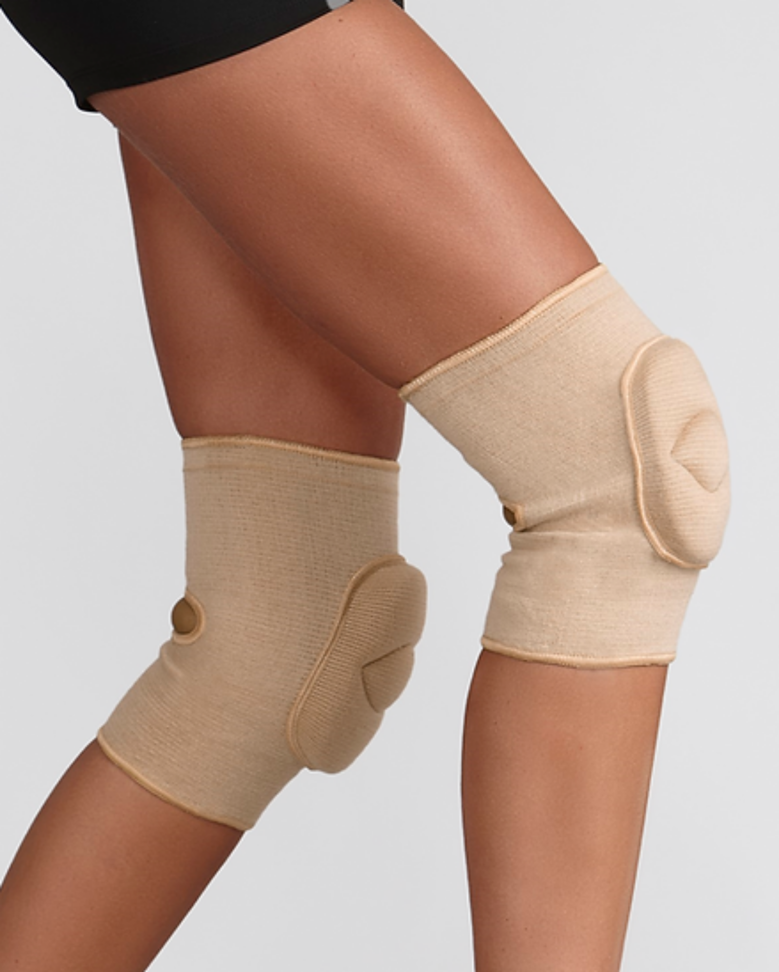Beige knee pad on a person's leg against a plain background