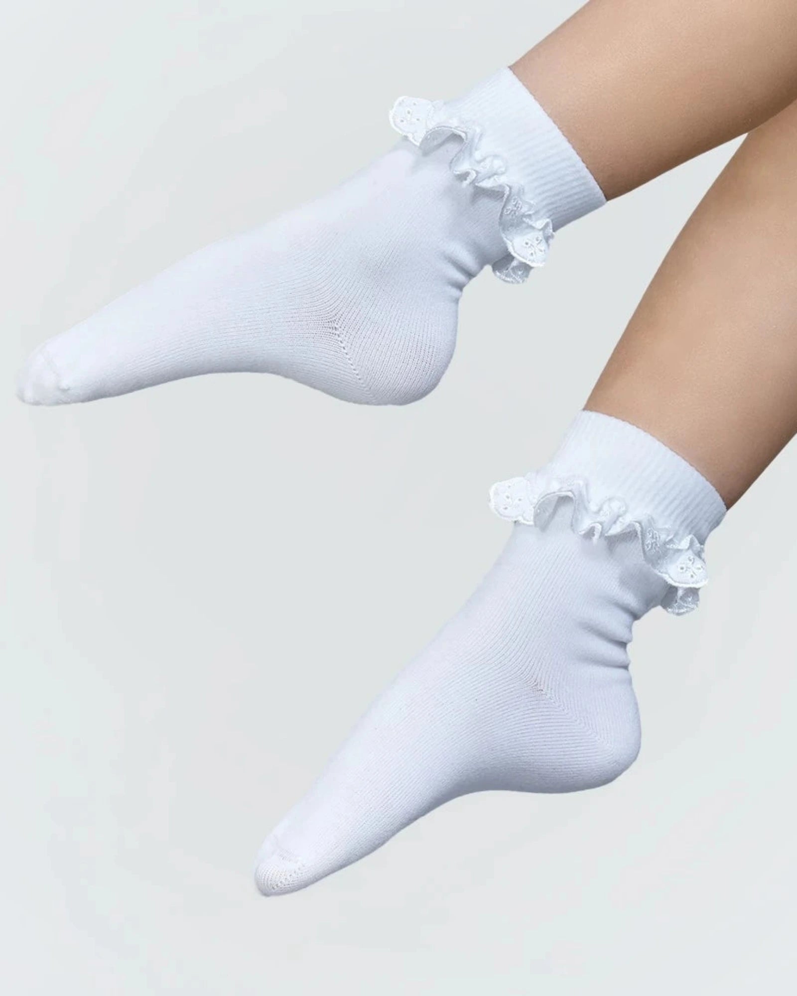 White socks with ruffles on a light gray background