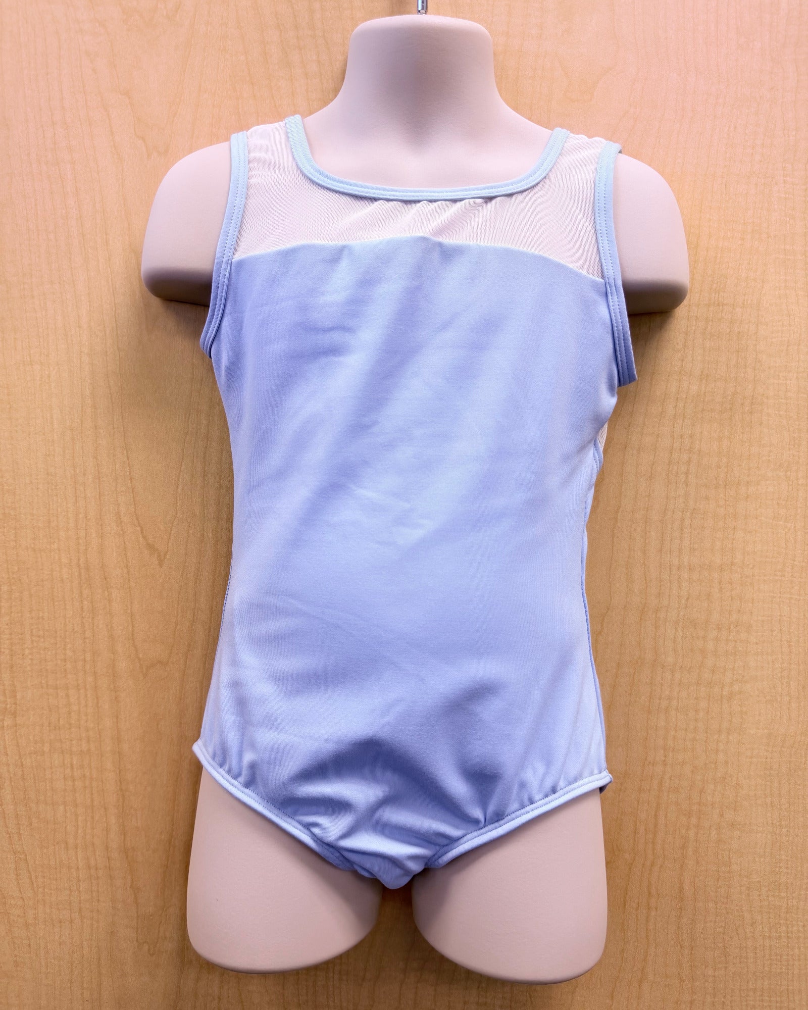 A light blue sleeveless dance leotard with a sheer mesh yoke and light blue trim, displayed on a pink mannequin torso against a light wood background.