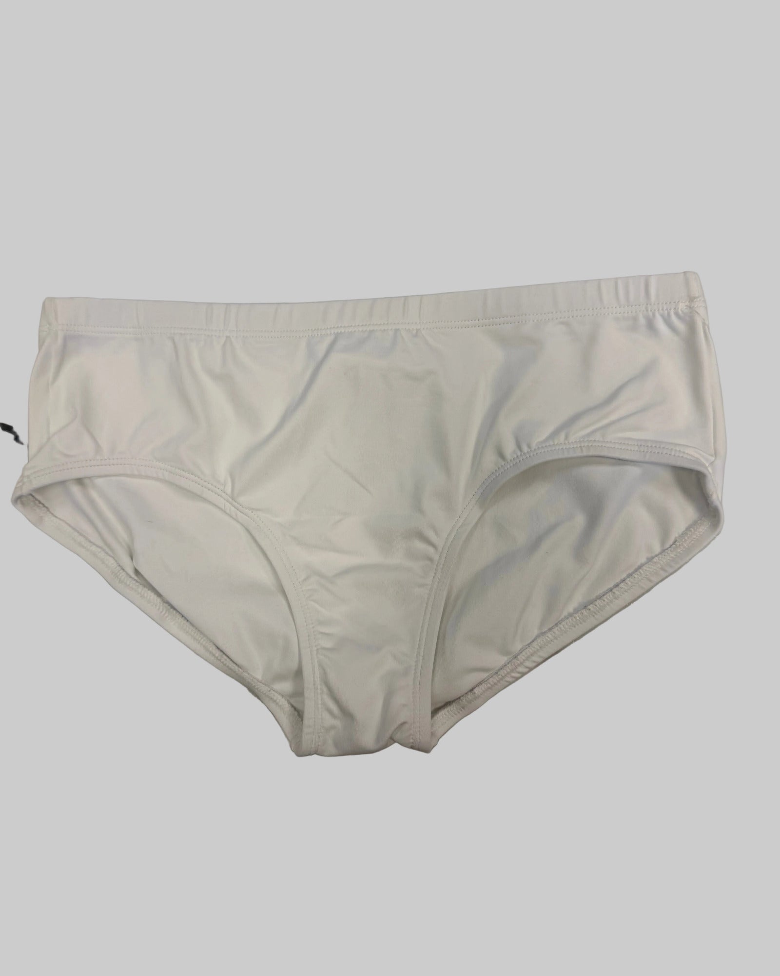 White seamless briefs laid flat on a white and gray marble surface.