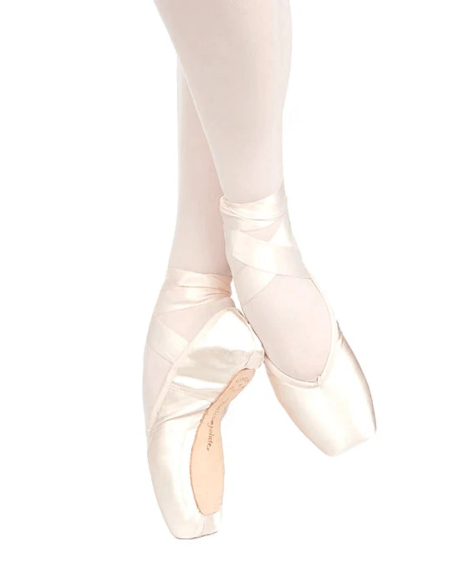A pair of pale blush pink satin pointe shoes worn on a dancer's feet, paired with matching light pink tights, shown against a solid white background.