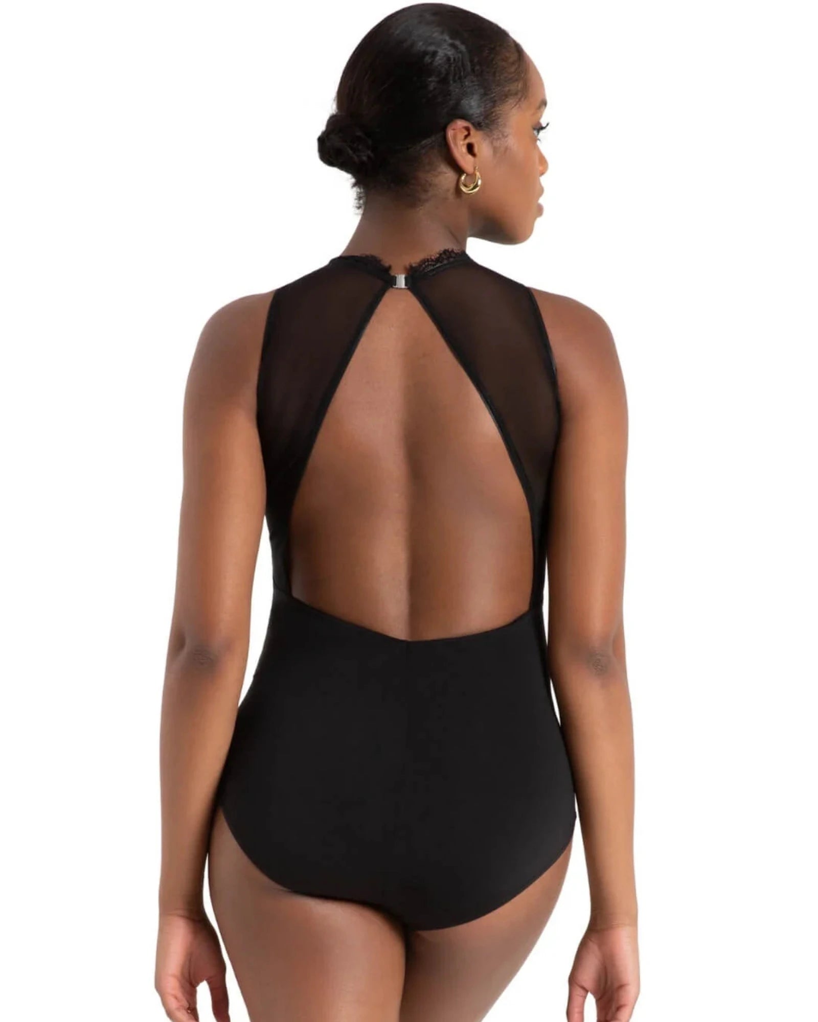 A woman shown from the back wearing a black leotard with a sheer mesh open back design, set against a plain white background.