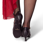 Black shoes with a visible brand logo worn with fishnet stockings and a red skirt.