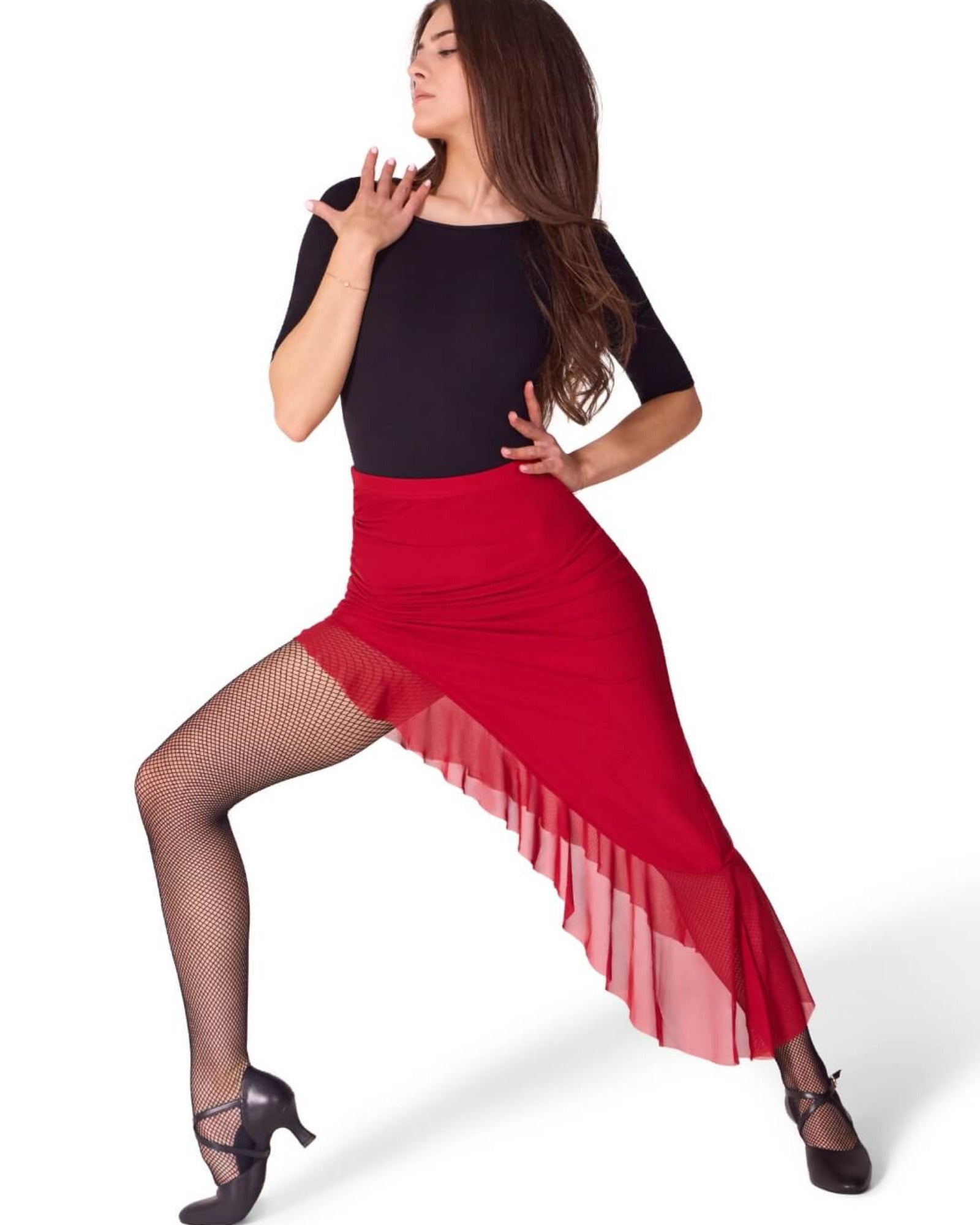 A woman modeling a red high-waisted tango skirt with a sheer ruffled hem, paired with a black top, fishnet tights, and black heels, posed against a solid white background.