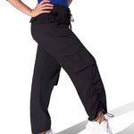 Person wearing black high-waisted pants with drawstrings on a white background