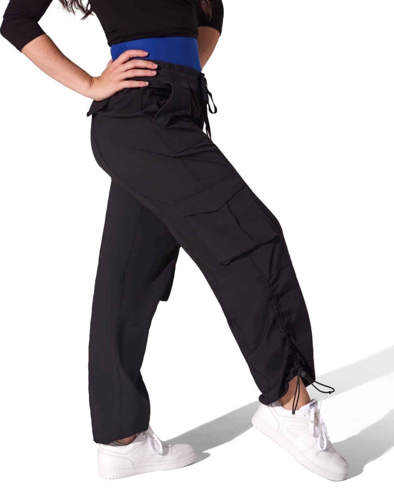 Person wearing black high-waisted pants with drawstrings on a white background