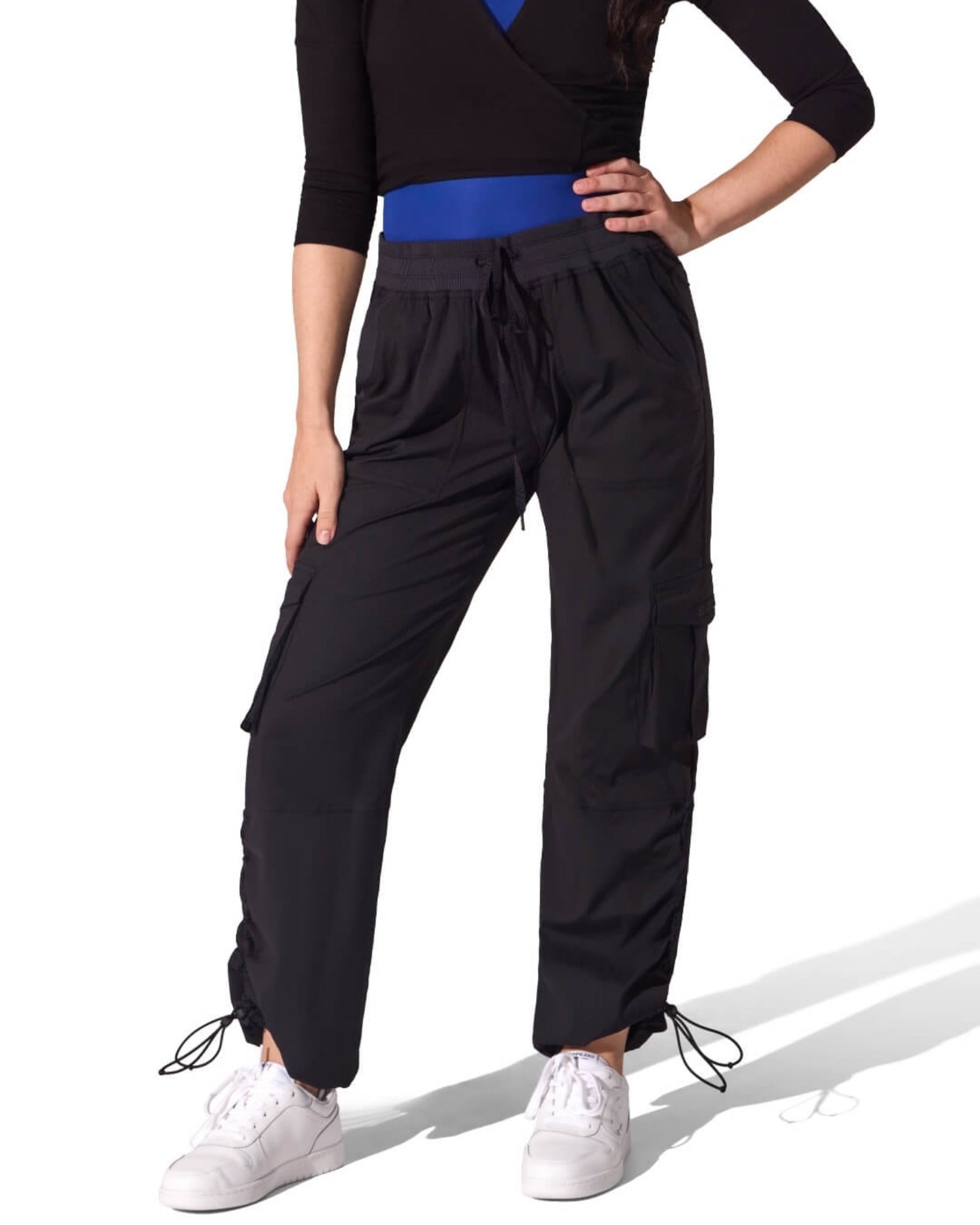 Person wearing black high-waisted pants with a blue belt on a white background