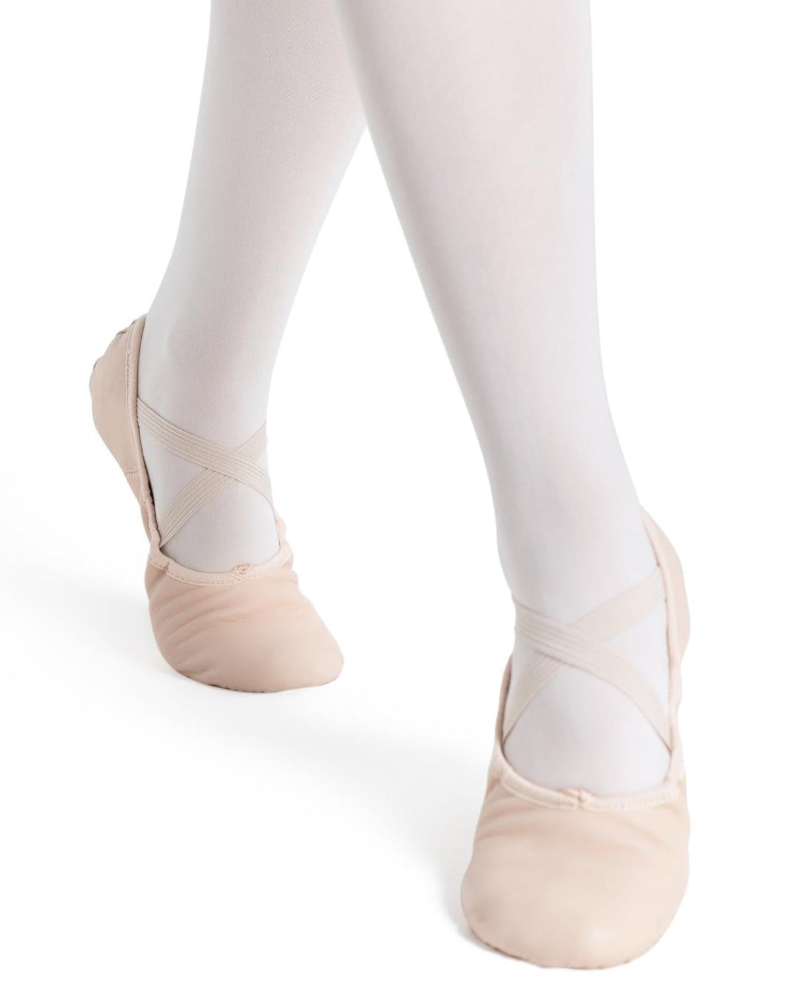 Ballet shoes worn with white tights on a white background