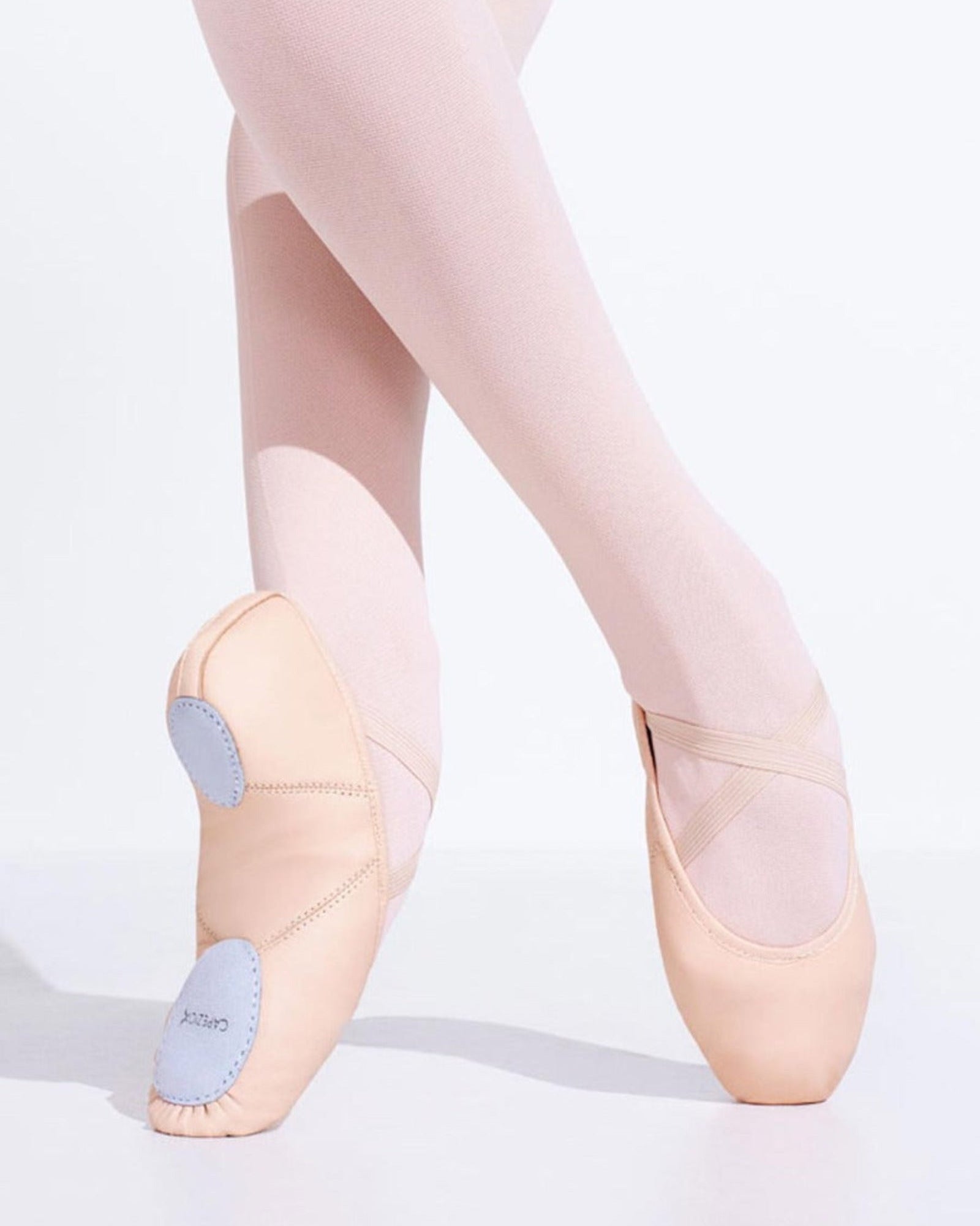 Ballet shoes with pink tights on a white background