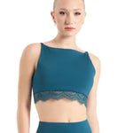 Woman wearing a teal dance bra and leggings on a white background