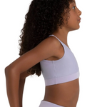Woman wearing a light purple bra top and leggings on a white background