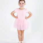 Young girl in a pink ballet outfit posing on a white background
