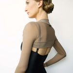 Woman wearing a black leotard with sheer sleeves against a white background