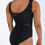 A woman shown from the back wearing a black one-piece leotard with sheer mesh panels at the back and around the waist, photographed against a light gray studio background.