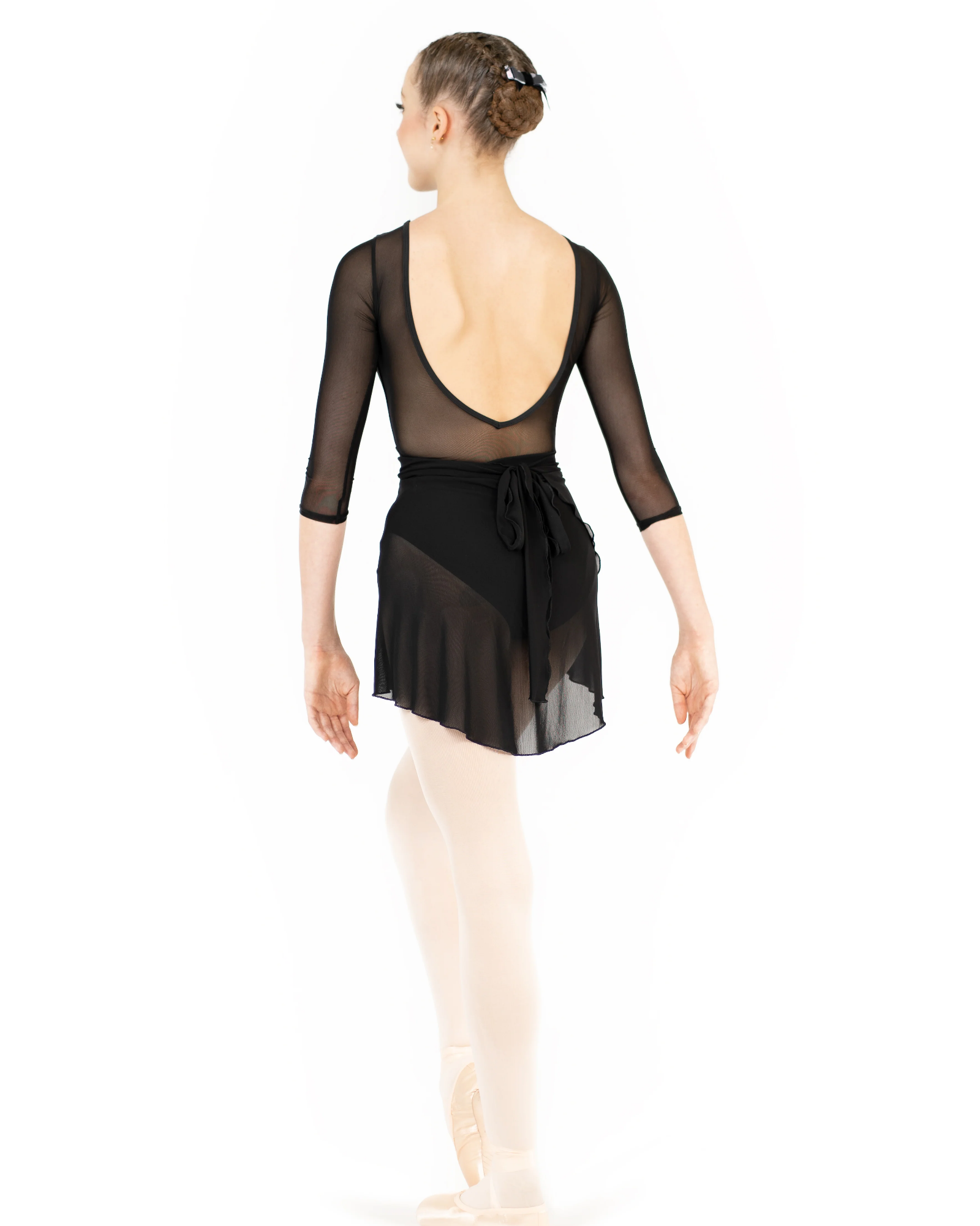 Ballerina wearing a black sheer top and white tights on a white background