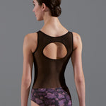 Woman wearing a black leotard with floral design on a gray background