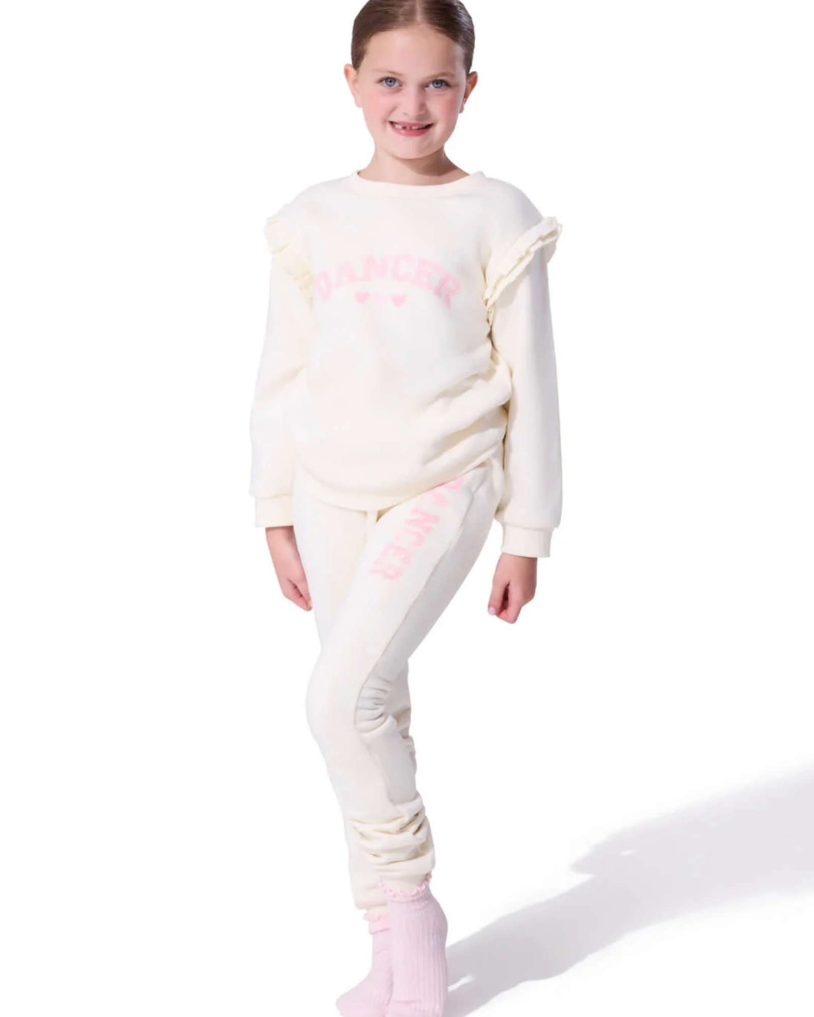 Young girl wearing a white outfit with pink accents on a white background