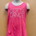 A bright pink sleeveless tank top with 'GOTTA DANCE' printed in white outline text across the front, displayed on a mannequin torso against a light wood background.