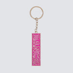 Keychain with 'DANCE!' text on a pink rectangular tag against a light gray background