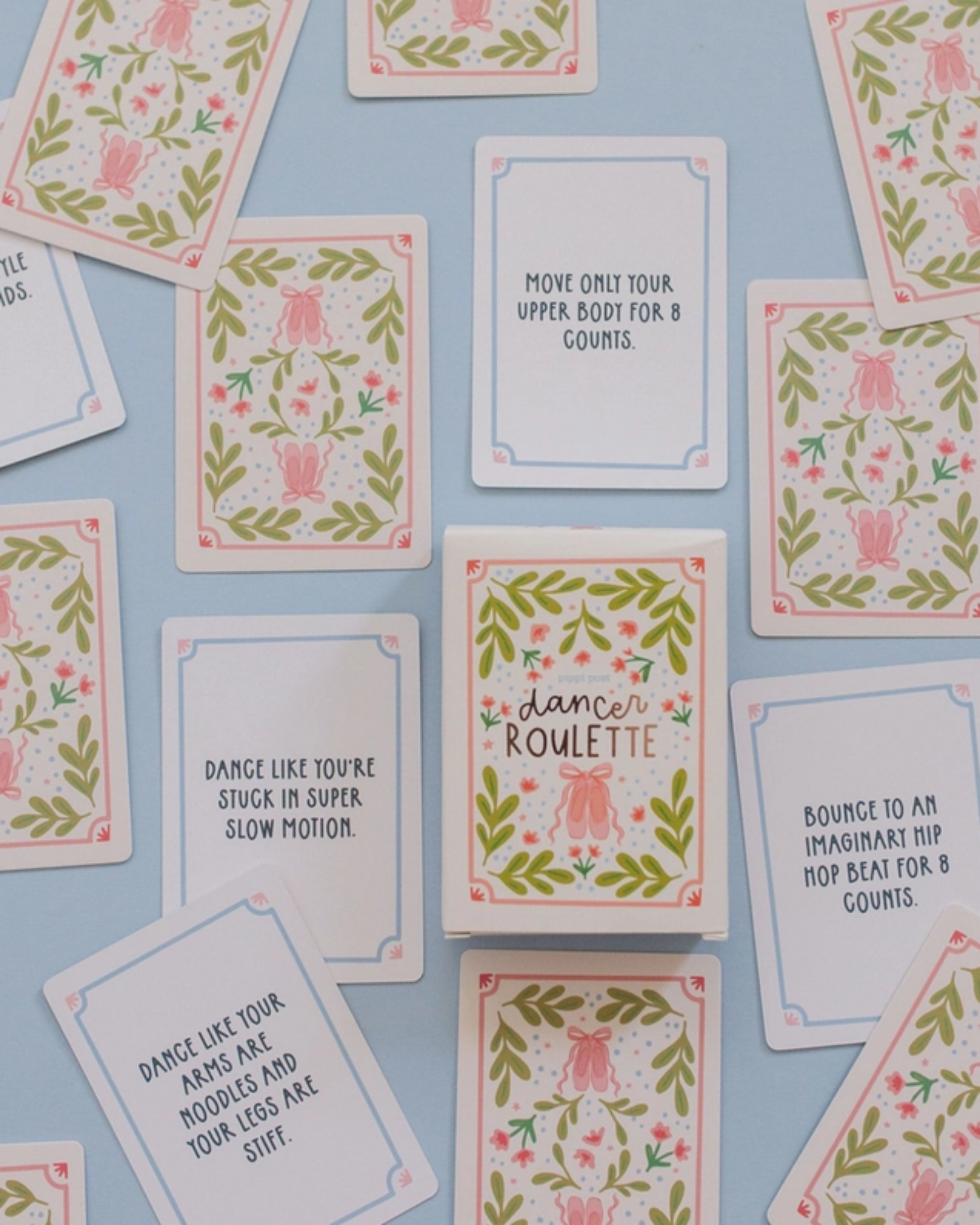 A flat-lay arrangement of square dance cards with pink floral and green leaf illustrations on a light blue background. The cards feature various dance and fitness quotes, including 'Dance like you're stuck in super slow motion' and 'Move only your upper body for 8 counts.