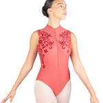 Dancer wearing a coral leotard with floral embroidery on a white background