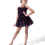 A young girl dancer wearing a black tulle tutu dress with a red strawberry pattern, posed against a solid white studio background.