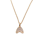 A gold-toned necklace featuring a pendant shaped like the tap shoe tap, adorned with small clear pavé stones, shown against a plain white background.